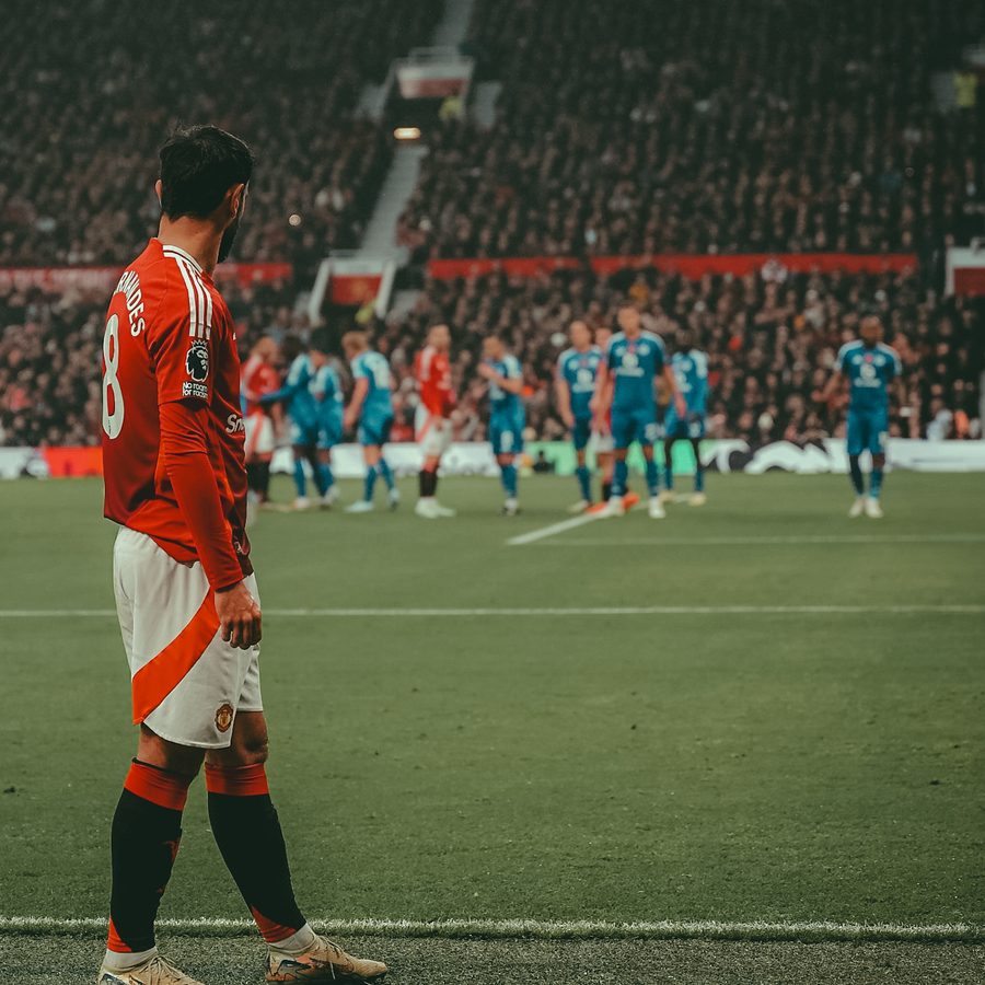 Footballer on the touchline at a packed stadium